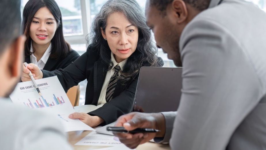 Business advisors presenting a performance graph to business owners during a strategic advisory meeting