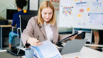 A business advisor examines financial documents.
