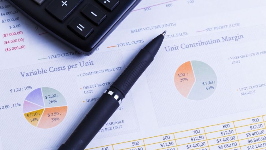 Black calculator and pen on accounting reports and charts