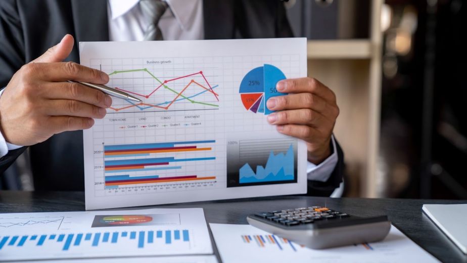 Close-up of a consultant presenting printed performance data to business owners during a meeting