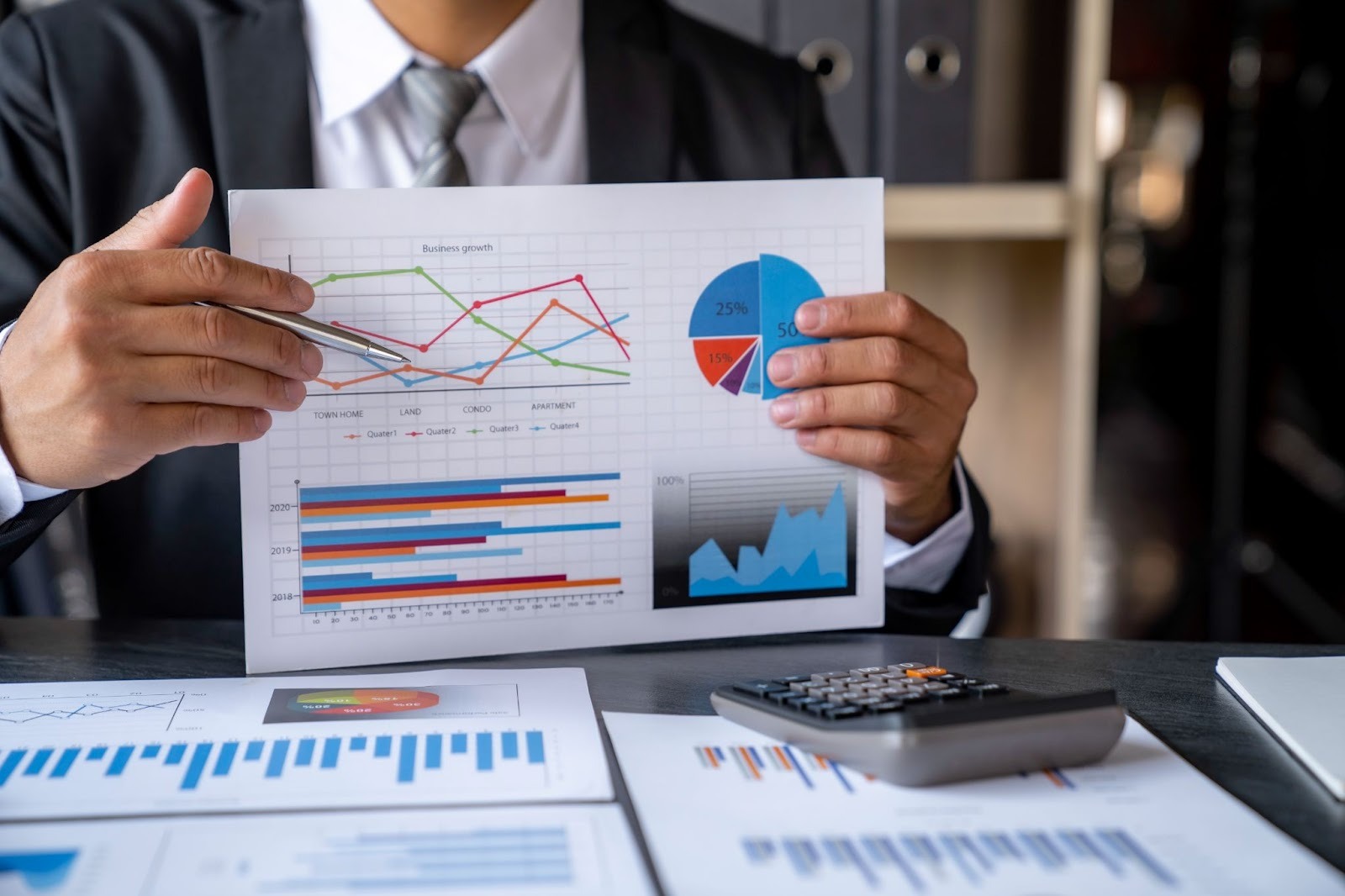 Close-up of a consultant presenting printed performance data to business owners during a meeting