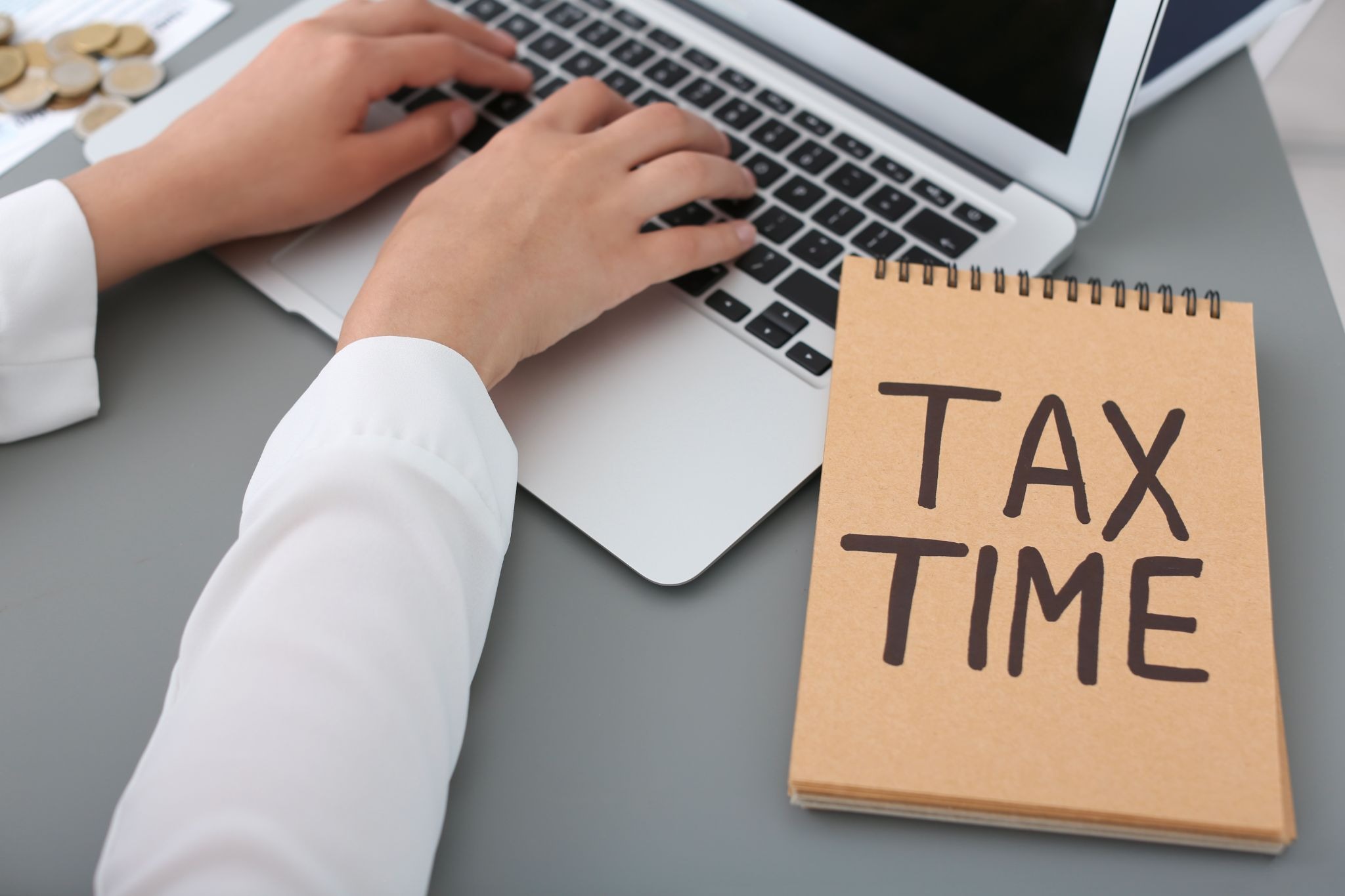 Professional bookkeeper updates the entries on a laptop to maintain organized financial data during tax time
