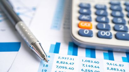 Close-up of a calculator and a pen on a financial report, highlighting accountancy services analysis for accurate business decision-making