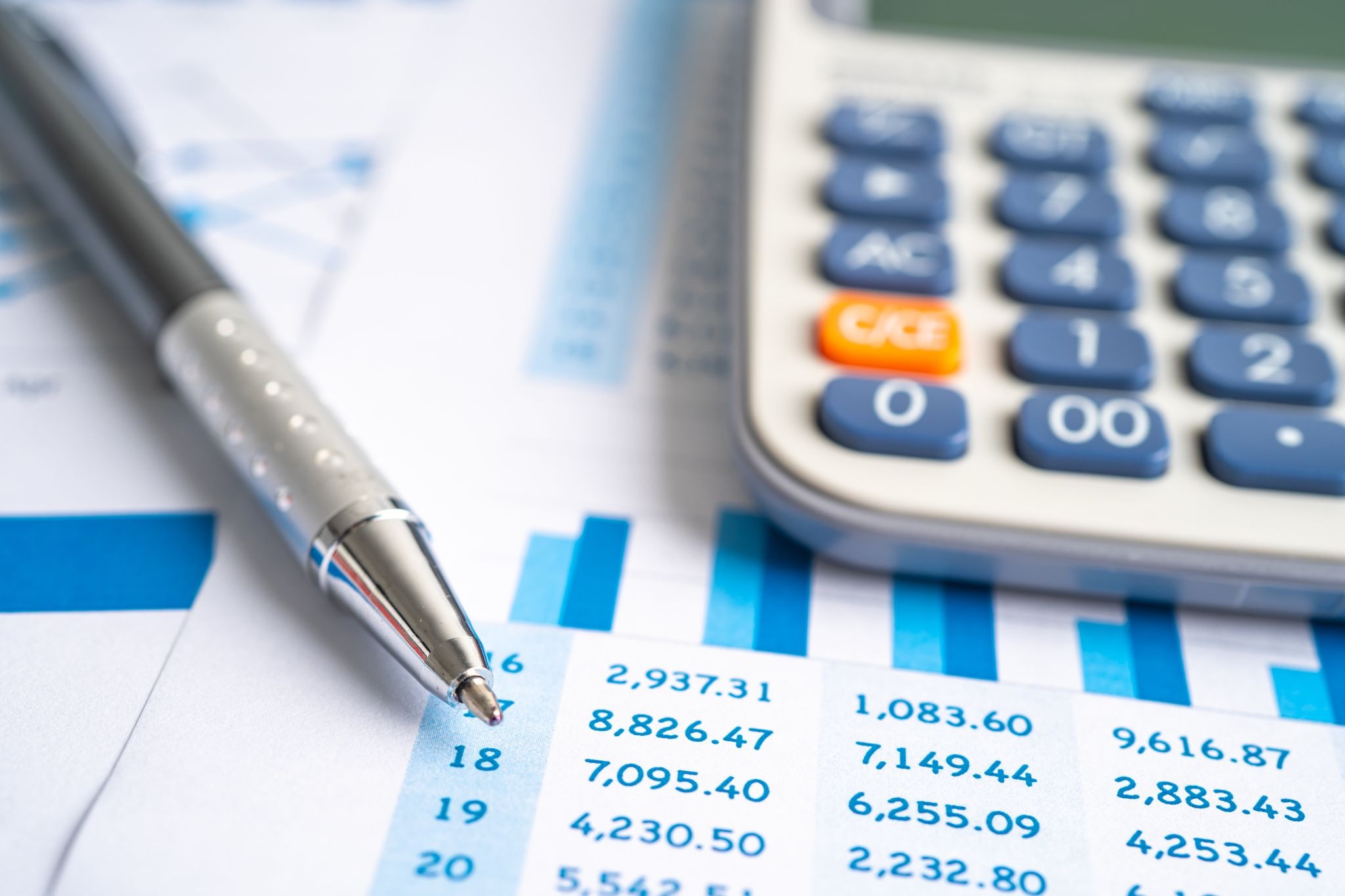 Close-up of a calculator and a pen on a financial report, highlighting accountancy services analysis for accurate business decision-making
